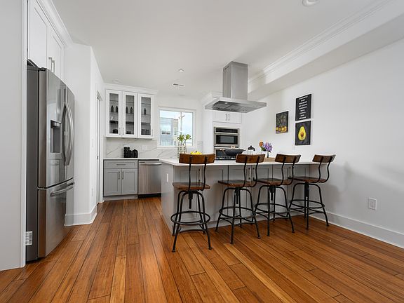 Kitchen with quartz island and counter top with filtered water and gas stove top