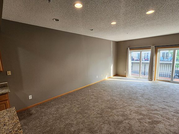 Main floor living room with walk-out to the sunny deck! New carpet!