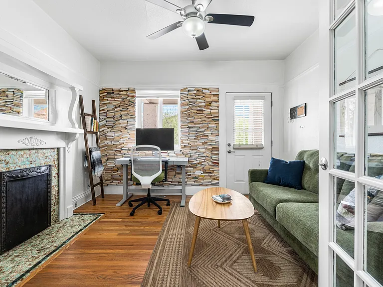 Bright & open living space with a decorative fireplace and custom floor to ceiling library wall __