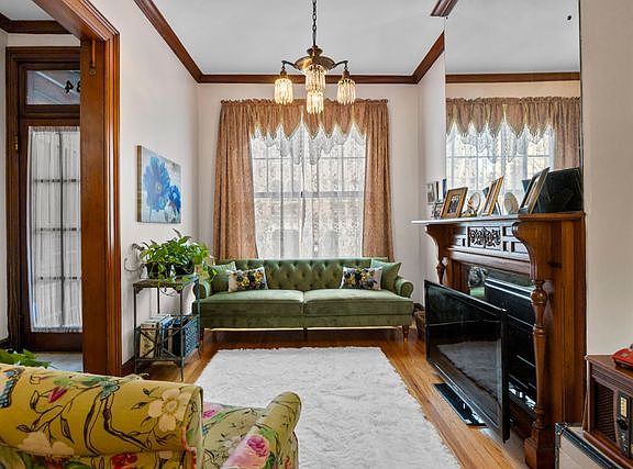 Front hallway and formal living room. Huge glass mirror over original fireplace mantle to the ceiling