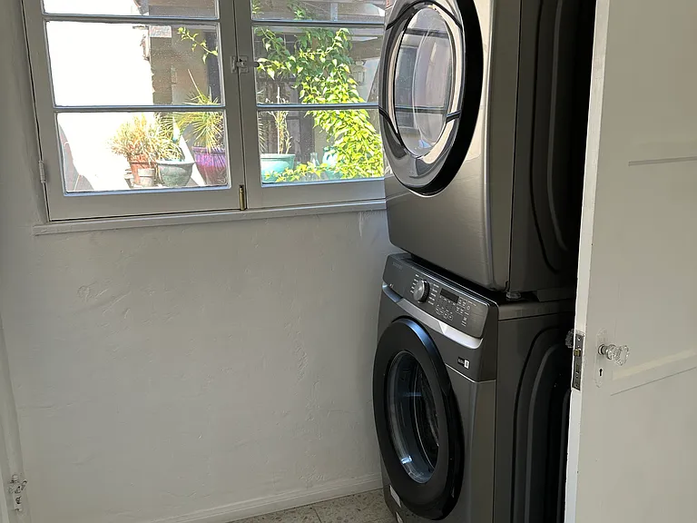 Large laundry room with new washer/dryer, walk-in pantry, built-in ironing board closet, and back door to stairs to carport