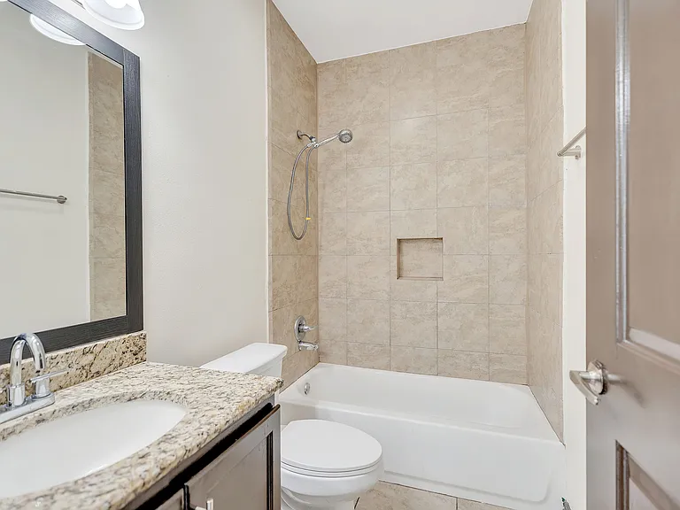 La Joya Apartments bathroom with a shower, toilet, and sink, highlighting a clean and contemporary design
