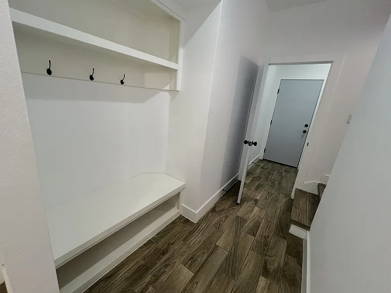 Mudroom and jackets area (left), washer and dryer room (center), stairs (right)