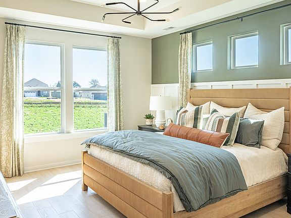 Primary Bedroom lined with windows, hard-surface flooring, and painted accent wall