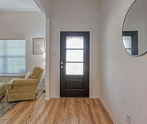 This beautiful entry door brings in natural light and has a smart lock for keyless entry