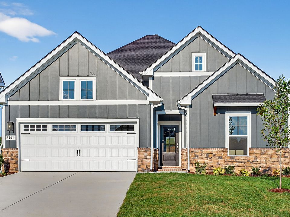 Elegant gray facade with stone details and gabled roof offers timeless luxury. Belmont, McClure Farm
