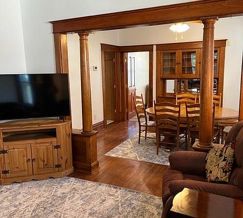 Living and dining area with buffet and bathroom door and kitchen entrance.