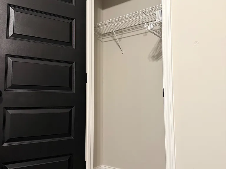 Closet with wire shelving and hanging space, offering practical storage for clothing and everyday essentials.