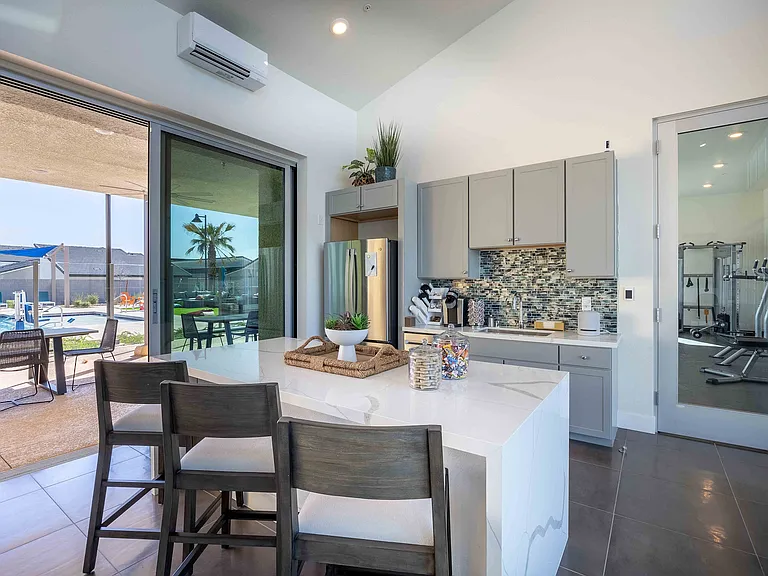 Experience sophistication in this modern kitchen with a scenic poolside vista.