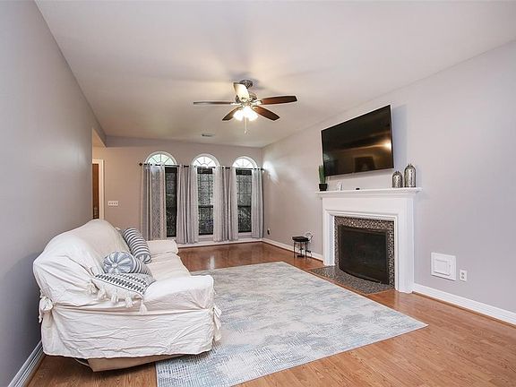 Gather the family and guests together in your lovely living room! Featuring high ceilings, dark stained ceiling fan, gorgeous floors, stunning fireplace, and large windows that provide plenty of natural lighting throughout the day!