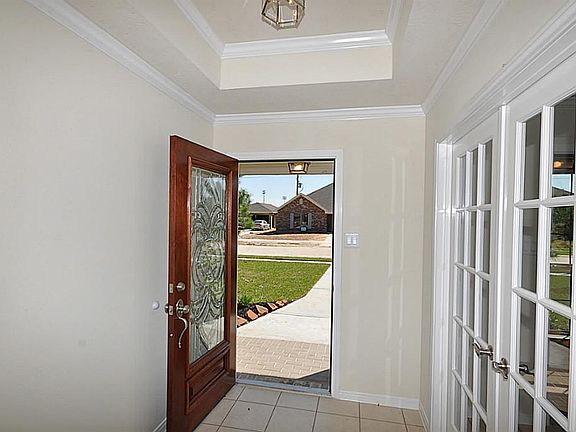 Elegant Foyer with quality crafted moldings, mahogany entry door and French Doors into the Study.
