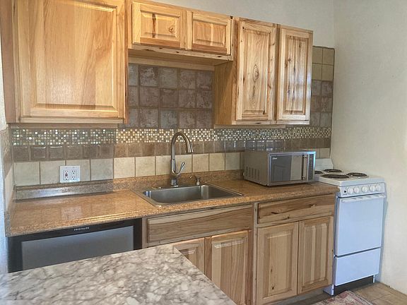 full kitchen with bar table and bar stools, new wooden cabinets, and kitchen amenities for cooking