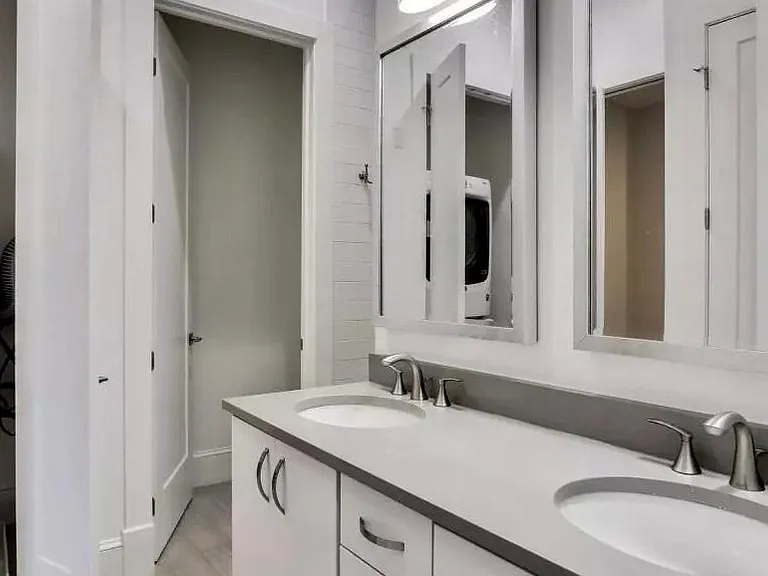 double sink master bath with separate toilet room and full size washer/dryer in laundry closet