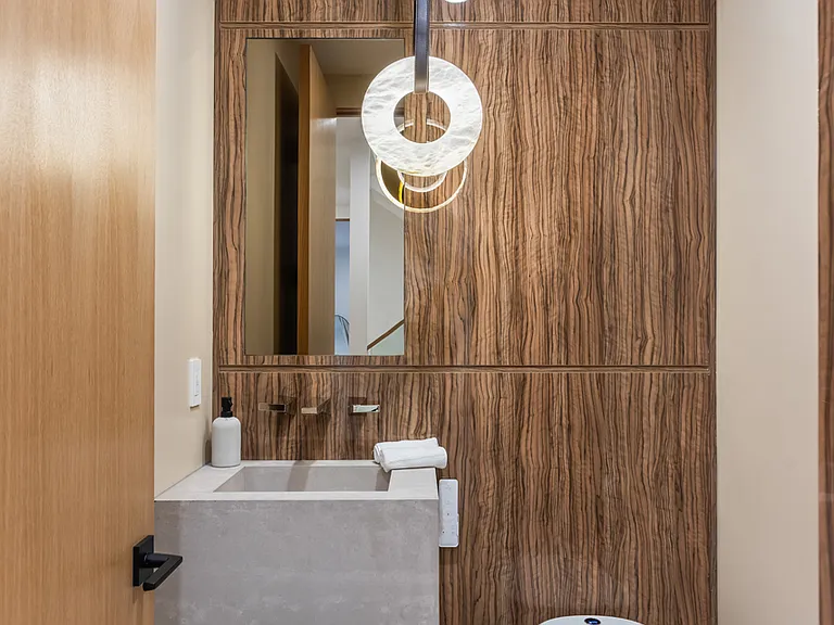 Italian wood panels are used for the walls for a meticulous modern look and feel in the powder room.