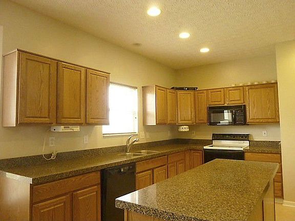 Large center-island kitchen with new granite counters and ceramic flooring.