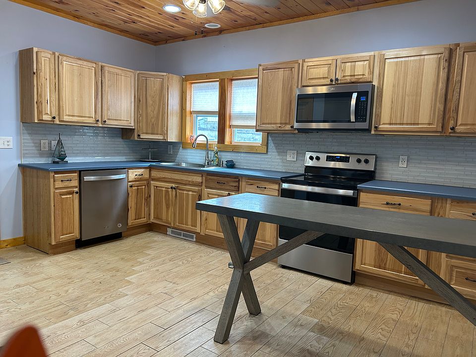 Kitchen with dishwasher, electric stove, microwave, refrigerator and large pantry.