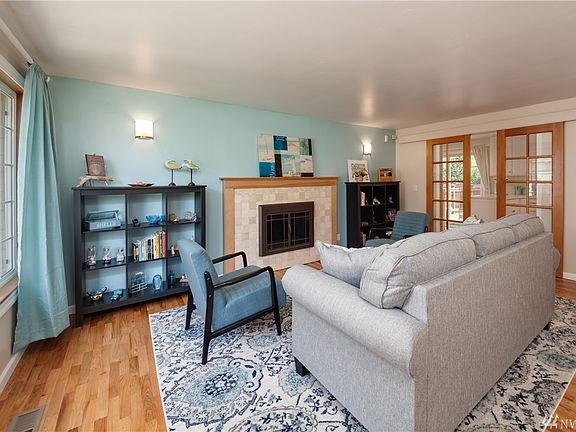 Formal living room with wood-burning fireplace and sliding barn doors to kitchen.