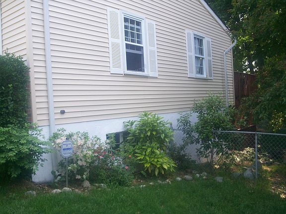 Side view of two story home.  Expert landscaping throughout grounds of home