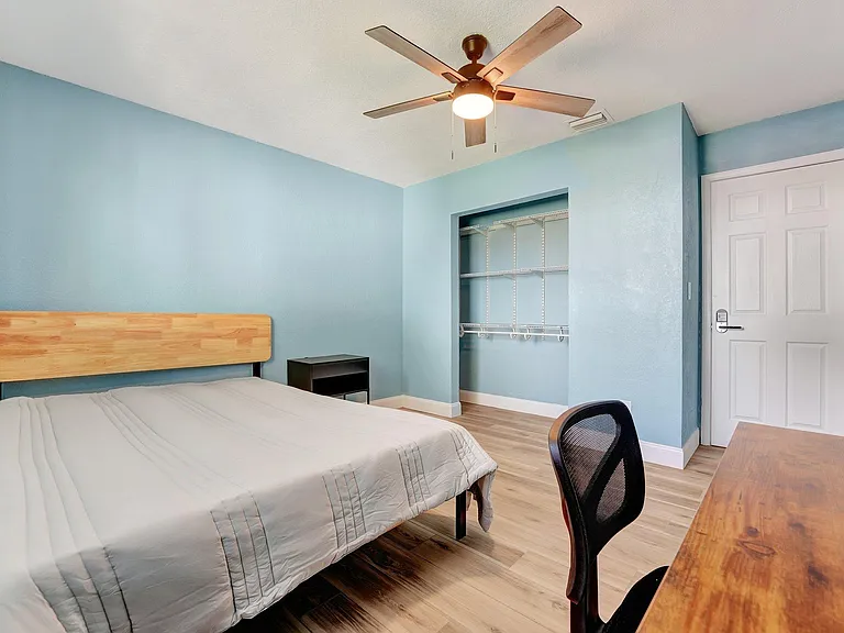 Bedroom with desk, tv and closet