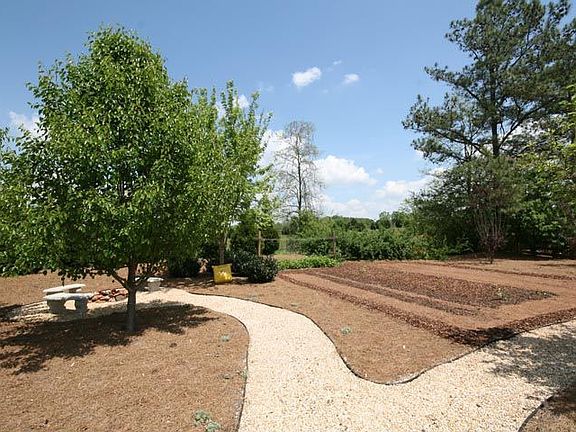 Backyard has steps leading up to path to firepit on left or vegetable garden!