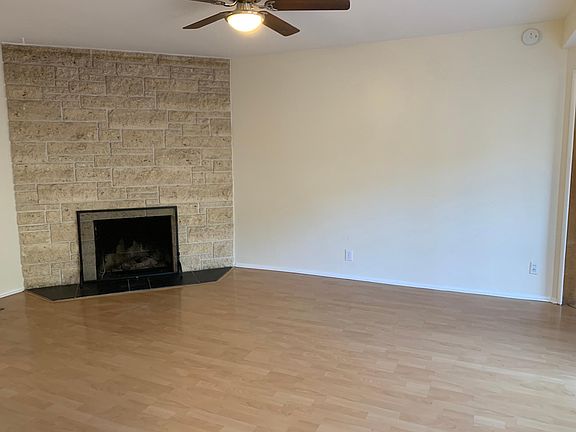 Living room with beautiful stone gas fireplace and ceiling fan