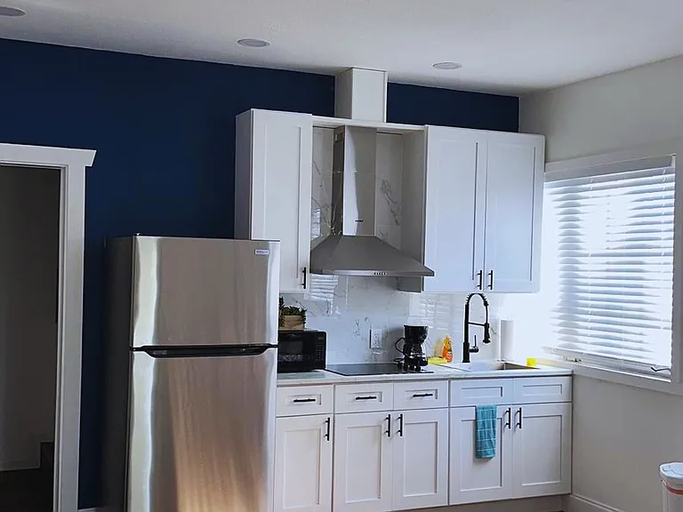 Modern kitchen with cabinets, microwave, coffee maker & essential amenities.