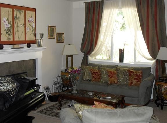 Open floor plan, elegant, spacious living room, gas fireplace, large picture window overlooking priv