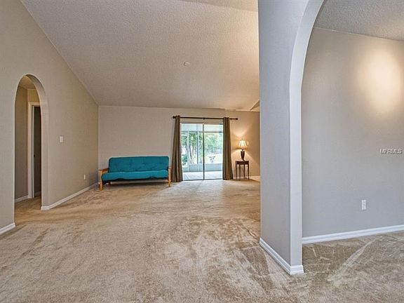 From entry looking into the huge great room and out into the porch and open back yard.  Dining room off to the right and the arched hallway to the left leads to one of the master suites and 2nd bedroom.