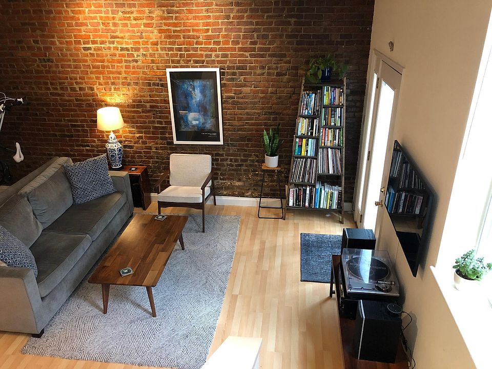 Living area with exposed brick and high ceilings