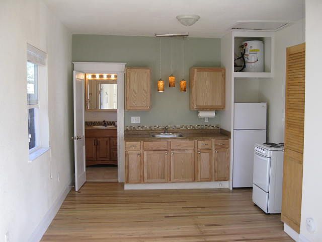 Kitchen area, refrigerator, stove, and pantry.