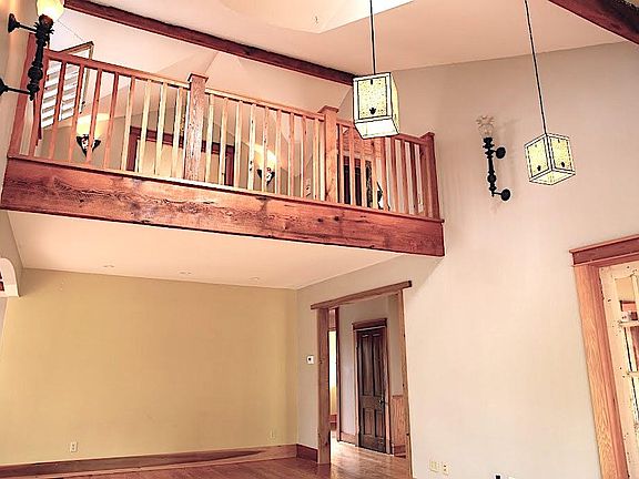 Second floor loft for bedroom or office space - overlooks living room, wall sconces, light from dormer above, transom in loft space
