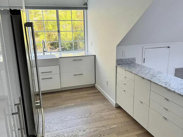 Kitchen with electric stove, ceramic farm-style sink and cabinets