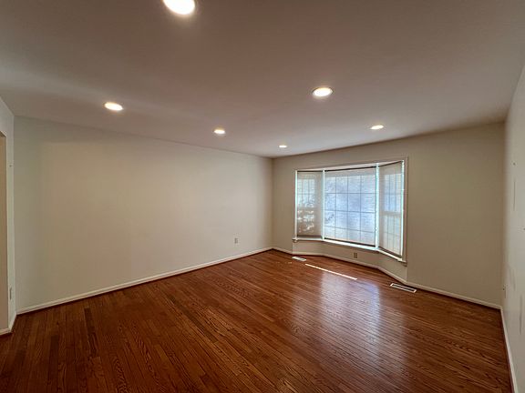 Living room w/ bay window, recessed lighting, and hardwood floors