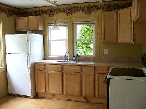 Eat in style kitchen. 15-lite Door in kitchen leads to back yead. White appliances (stove + fridge)