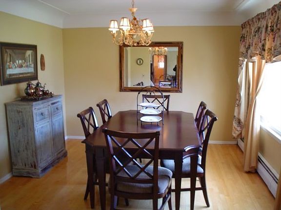 Formal dining room w/ hardwood floor, cove ceiling and antique lighting.