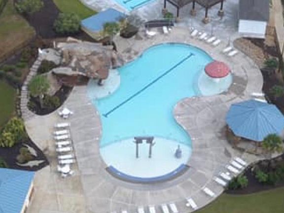 View of both recreation pool and lap pool. Club house and playground attached.