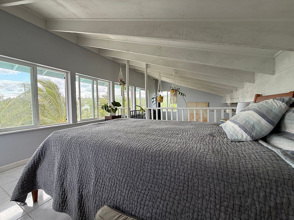 Lofted bedroom has peakaboo ocean glimpses.