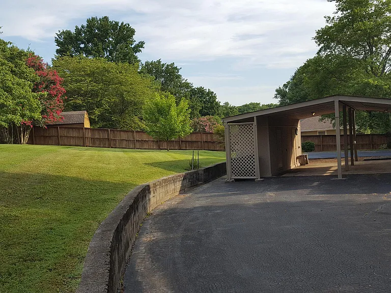 Back yard extends up the hill near the structure on the other side of the fence. This area is very nice for picnics and to lay on the thick grass and read a book or look at stars.