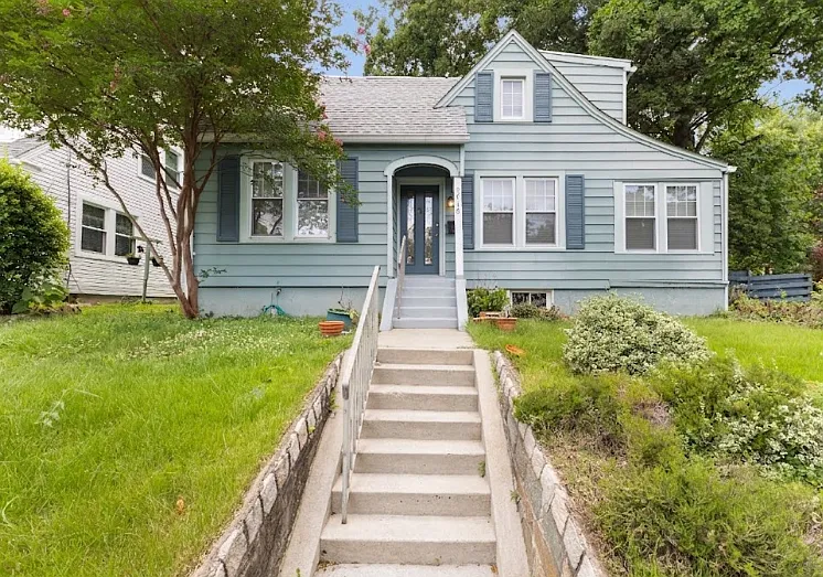 Welcome home! Charming curb appeal with a lovely front yard and welcoming steps.