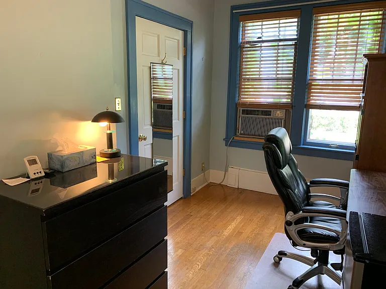 1st floor - east facing sun room / bedroom w/hardwood floors and 9' ceiling; premium fully adjustable leather chair and desk and armoire closet; glass topped dresser