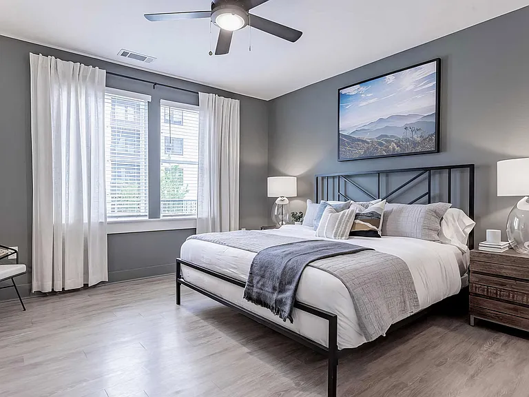 Spacious primary bedroom with dark gray walls and ceiling fan