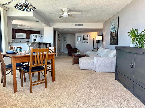 The main living area with dining, sectional couch, and a cube-shaped Murphy bed (expands to a queen-sized bed).