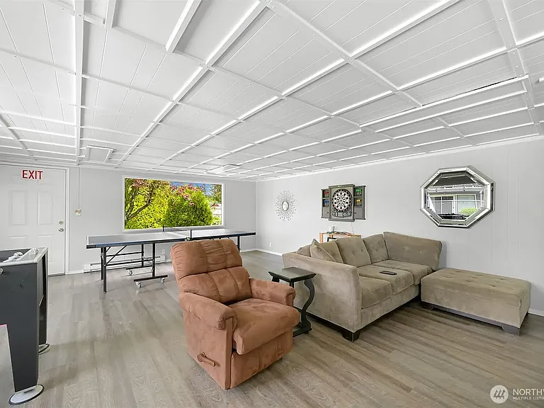 Fussball, ping pong table, and seating area next to a large scale smart TV.