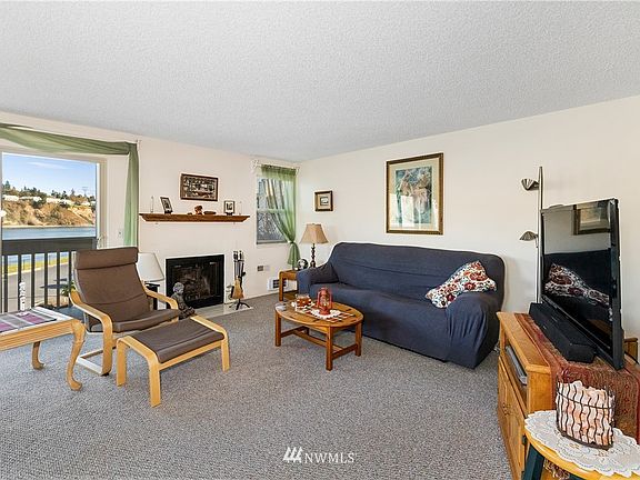 Living room with fireplace and oak mantle shown.