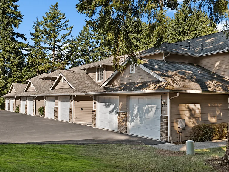 Townhome-style living with private garages and peaceful wooded surroundings.