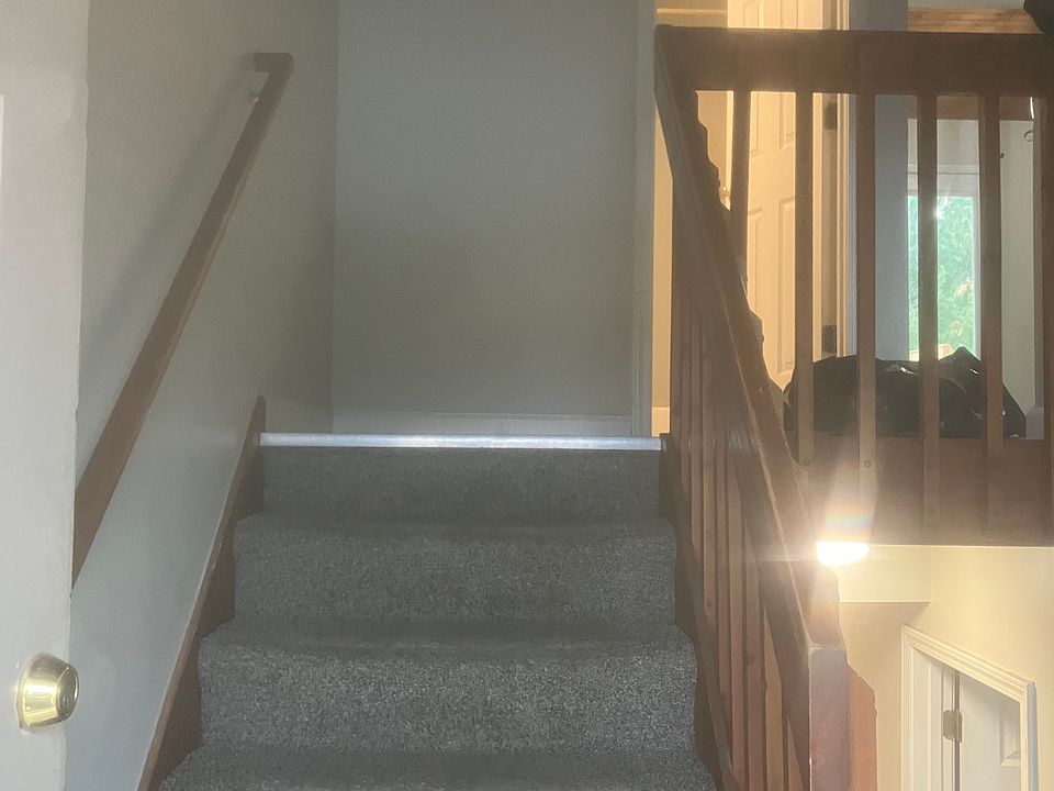 Stairway from landing upstairs to upstairs bathroom, living room, kitchen and deck