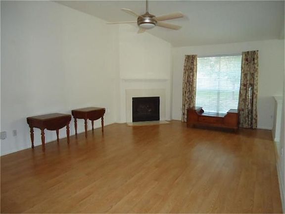 Spacious living room with laminate wood floors and corner gas log fireplace.