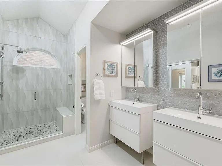 Double vanity in primary bathroom with separate toilet room.