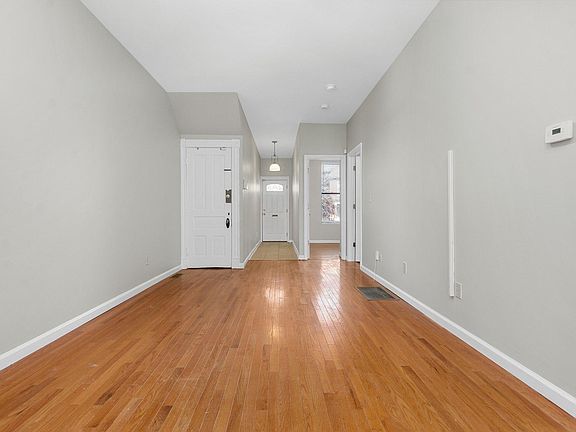 View from kitchen to entry and secondary bedroom and door to basement.