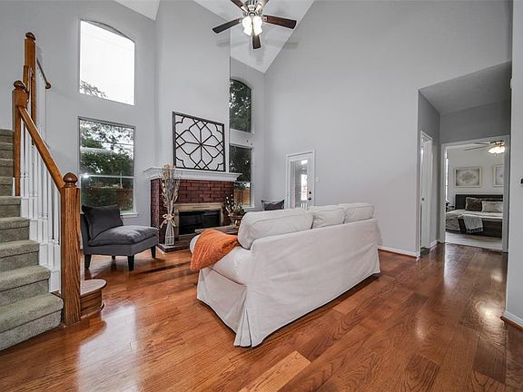 Living area with high ceilings, fireplace, gorgeous flooring and tall windows!